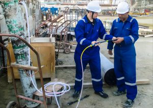 Two workers inspecting industrial equipment.