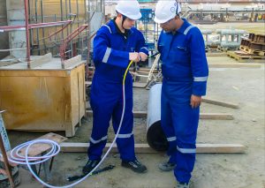 Two workers inspecting equipment at construction site.