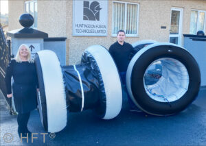 Two people with large inflatable pipe plugs.
